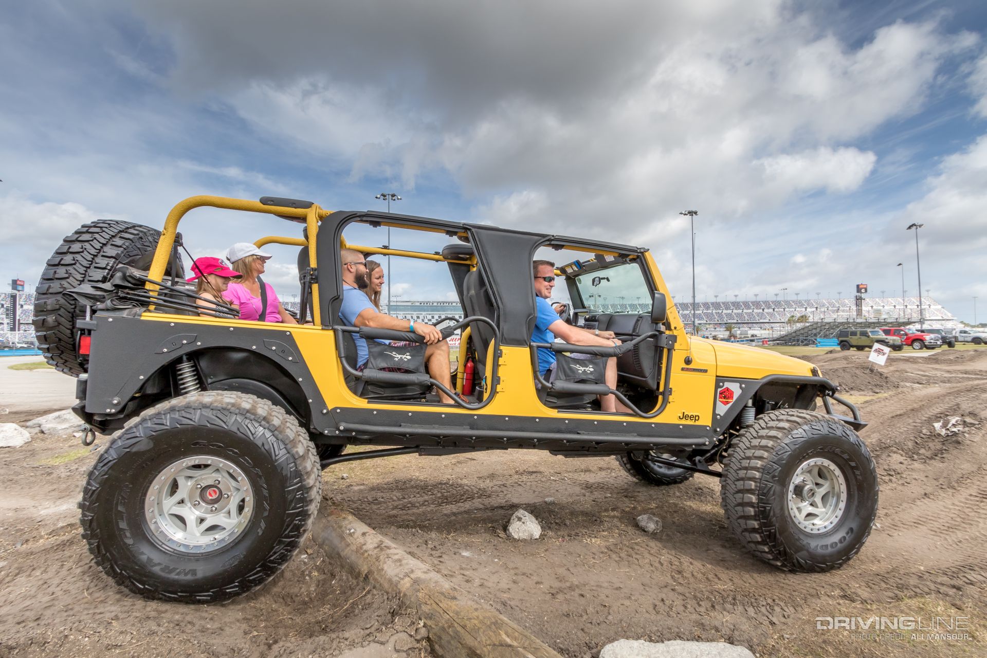 Large, yellow Jeep with a family inside at Jeep Beach