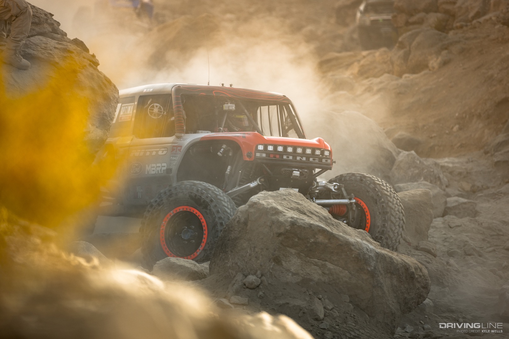 Loren Healy driving over a rock in a canyon