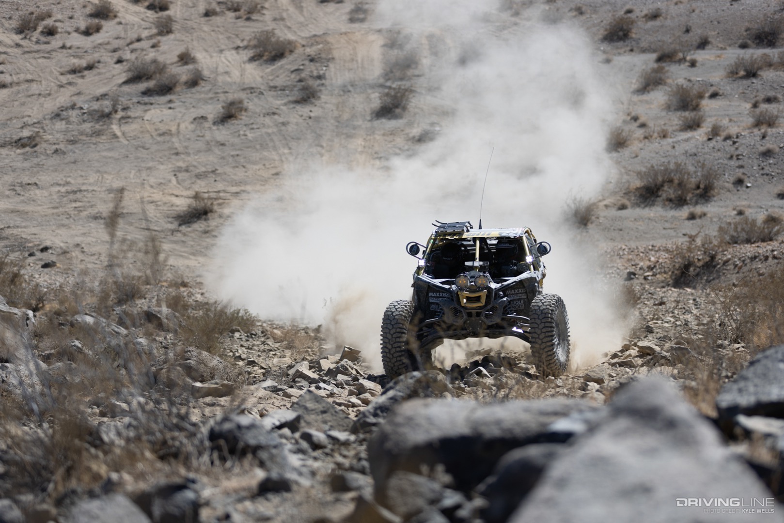 Kyle Chaney driving from the desert into a rocks section