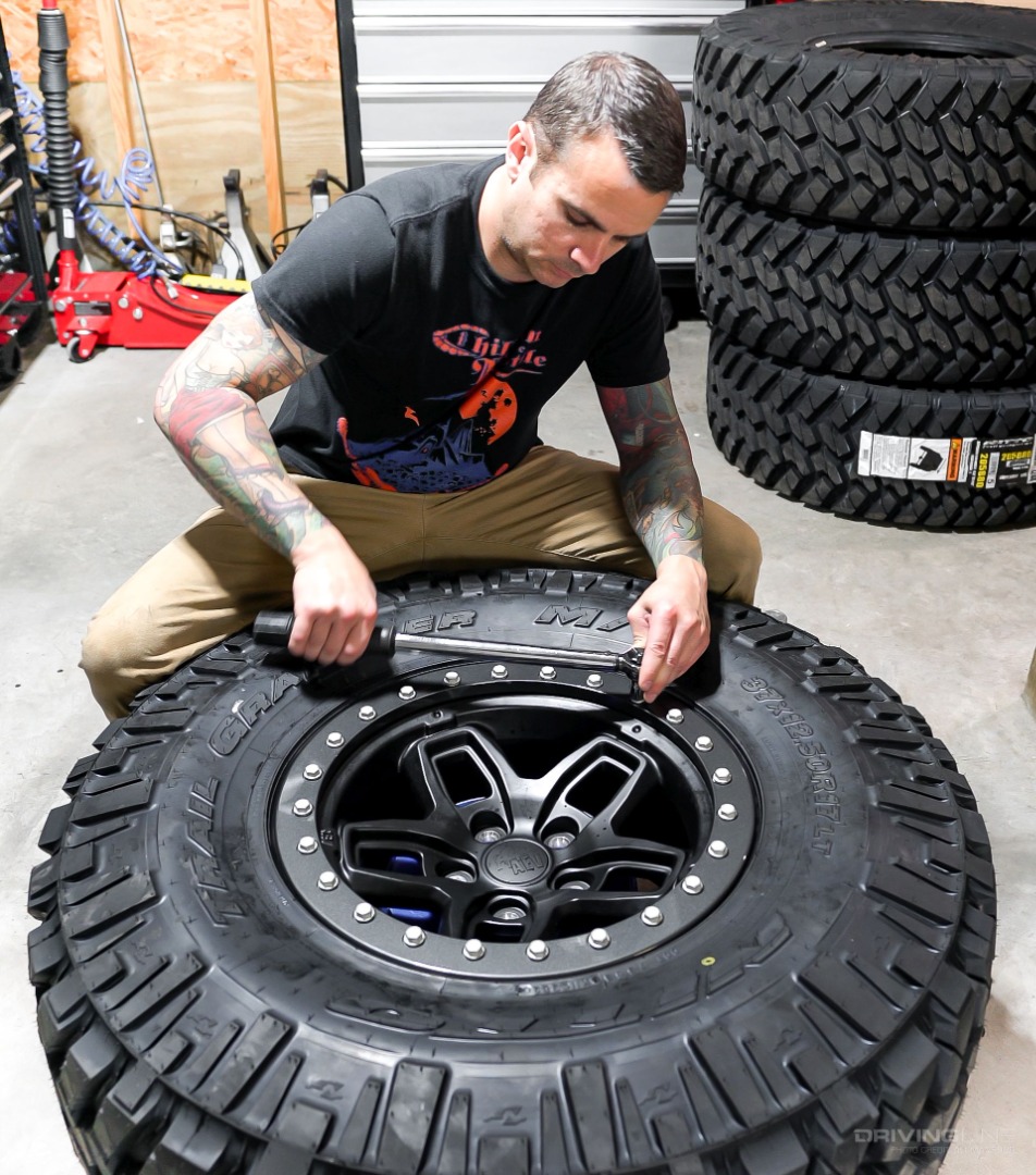 Ali Mansour using a torque wrench on a beadlock rim and Nitto Trail Grappler tires