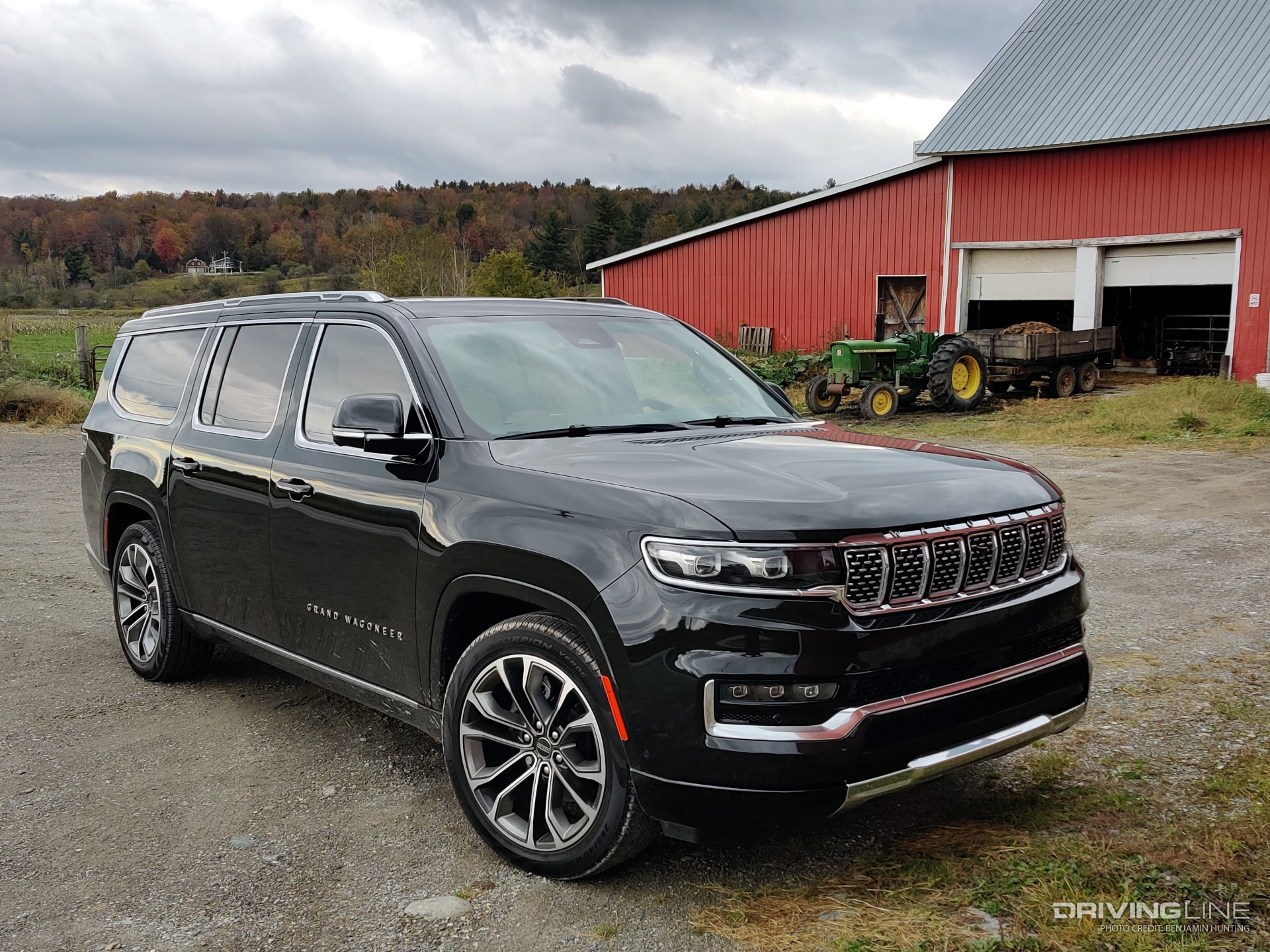 2023 Jeep Grand Wagoneer L parked on a farm with tractor in the background