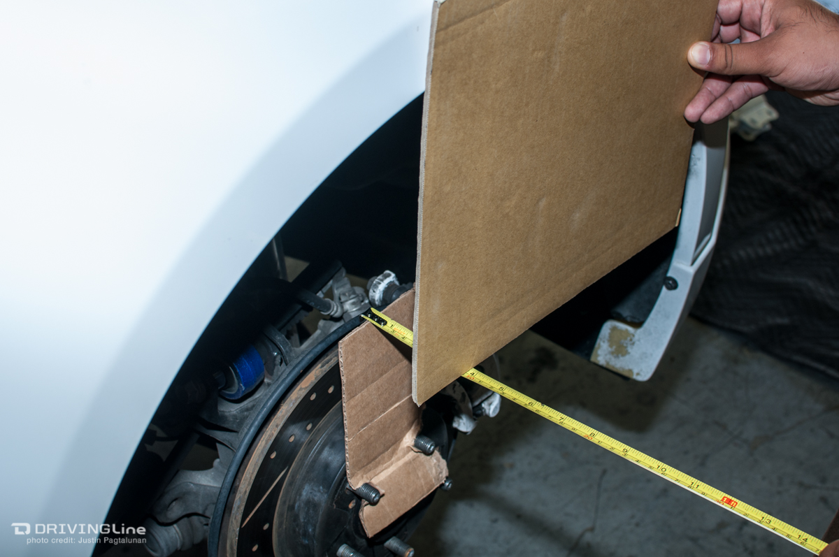 Man measuring the distance from the hub to front of wheel well