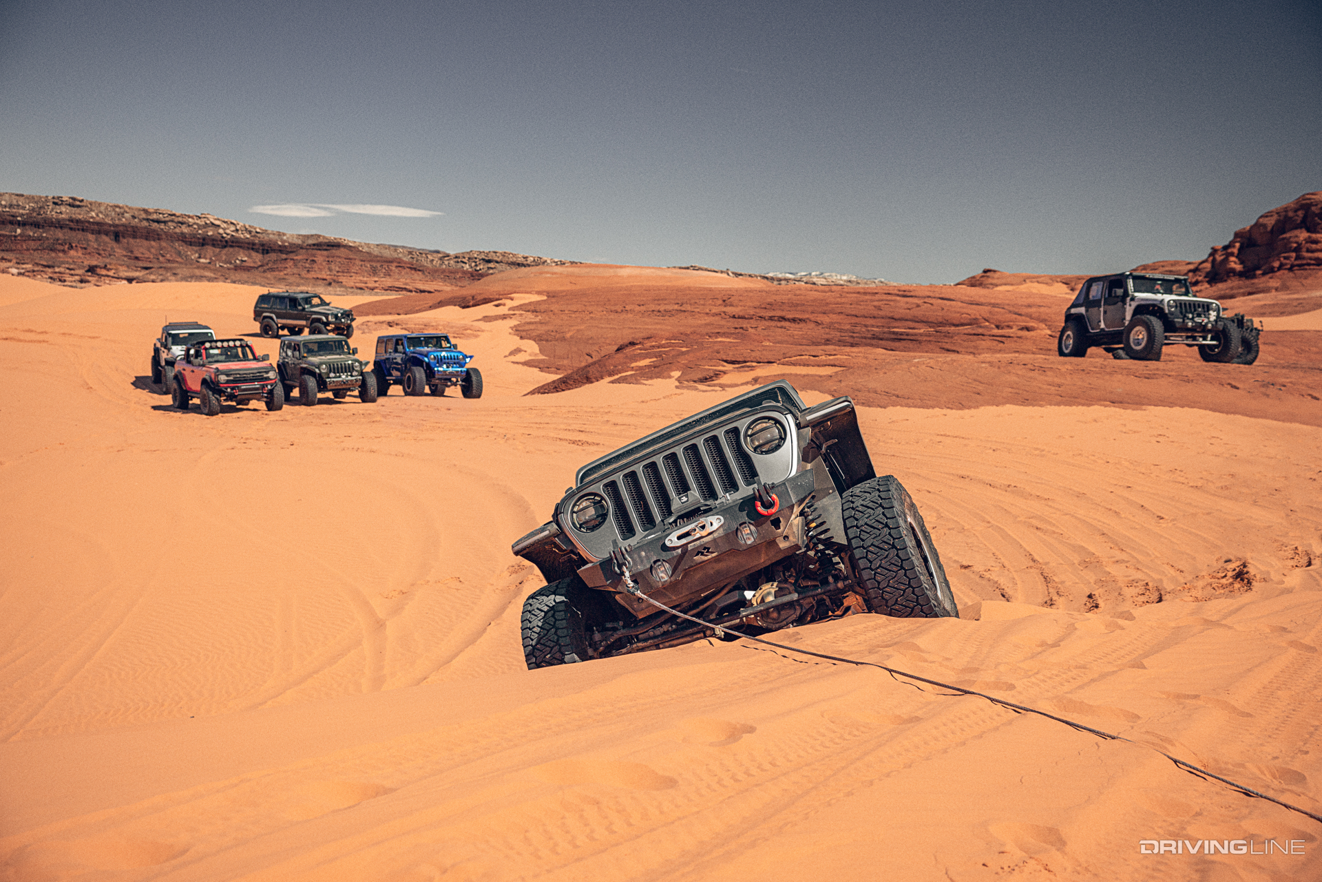 Jeep using recovery cable in sand dunes